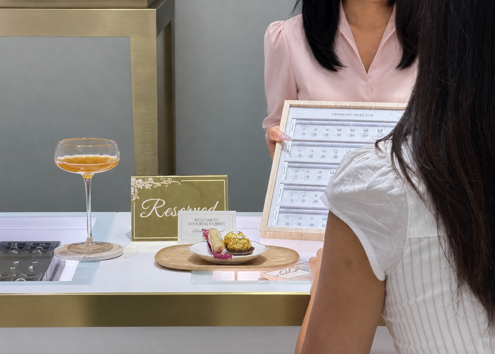 A Hung Phat consultation in progress &mdash; champagne, chocolates, a Reserved card, and the diamond selector at the consultation table